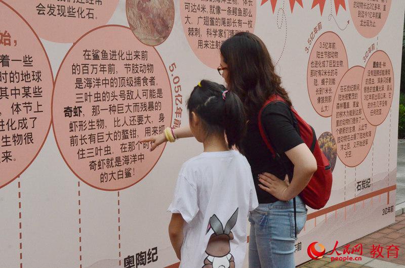 圖為家長和孩子駐足觀看科普知識 王子文/攝