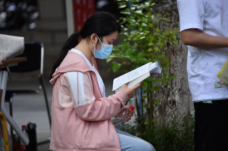 6月7日，江西省南昌市第十二中學(xué)考點(diǎn)，利用排隊(duì)的間隙，考生們抓緊時(shí)間復(fù)習(xí)。人民網(wǎng) 時(shí)雨攝