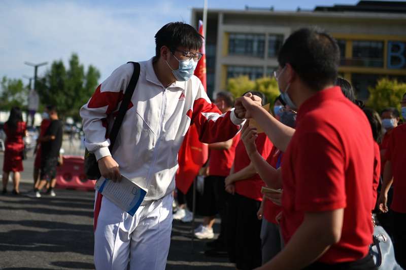6月7日，在北京市人大附中通州校區(qū)考點，考生與送考老師擊拳加油。人民網(wǎng)記者 翁奇羽攝