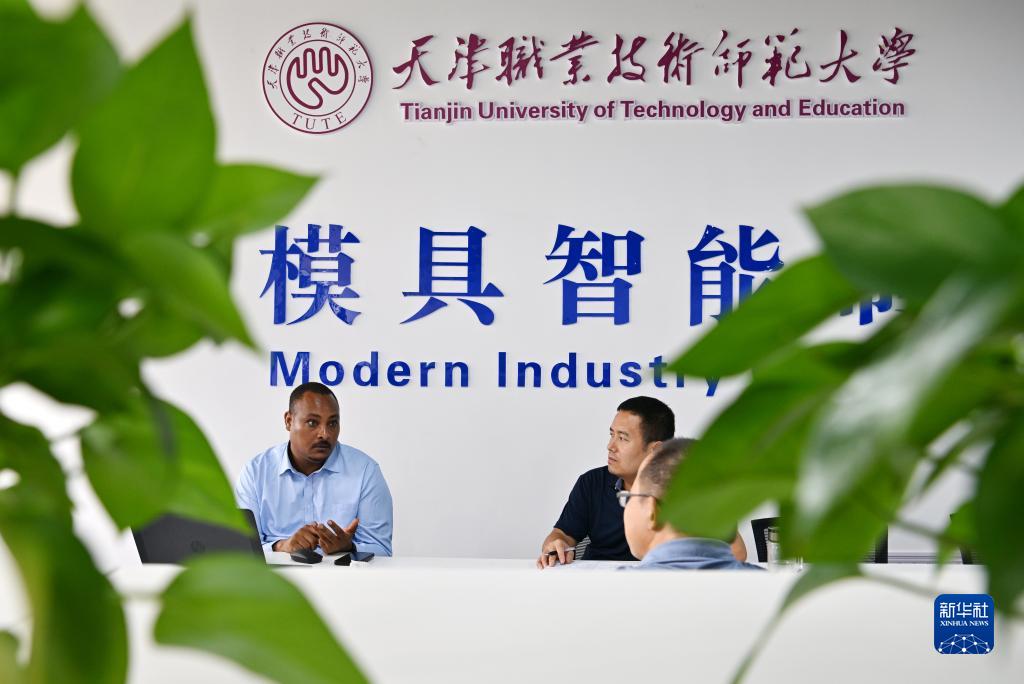 在天津職業(yè)技術師范大學，韓士蘭（左一）和老師們交流（8月12日攝）。新華社記者李然攝