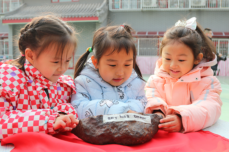 在北京市第一幼兒園吉祥魏家分園舉行第九屆“科學節(jié)”活動上，小朋友們正在觀察隕石。校方供圖