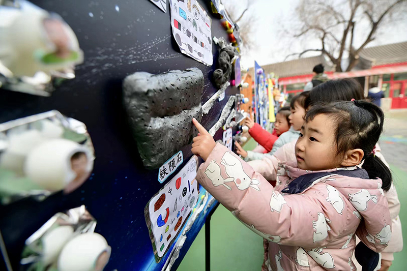 在北京市第一幼兒園吉祥魏家分園舉行第九屆“科學(xué)節(jié)”活動上，小朋友們正在觀察隕石。校方供圖