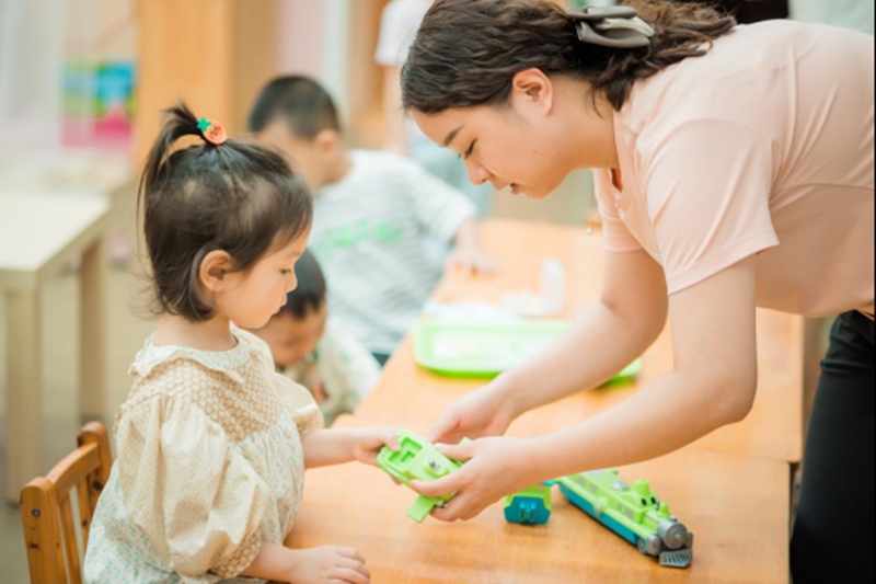教師與孩子一起玩玩具。園方供圖