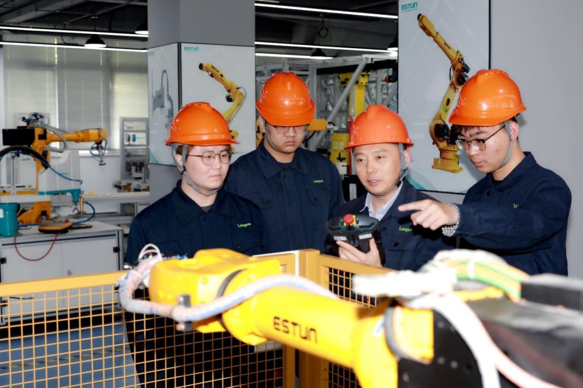 教師正在指導(dǎo)企業(yè)員工進(jìn)行機(jī)器人編程與運(yùn)維。學(xué)校供圖