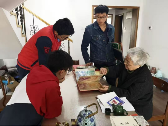 2019年，岳同給來(lái)家看望的志愿者們展示收藏的剪紙、中國(guó)畫作品。中國(guó)人民大學(xué)供圖