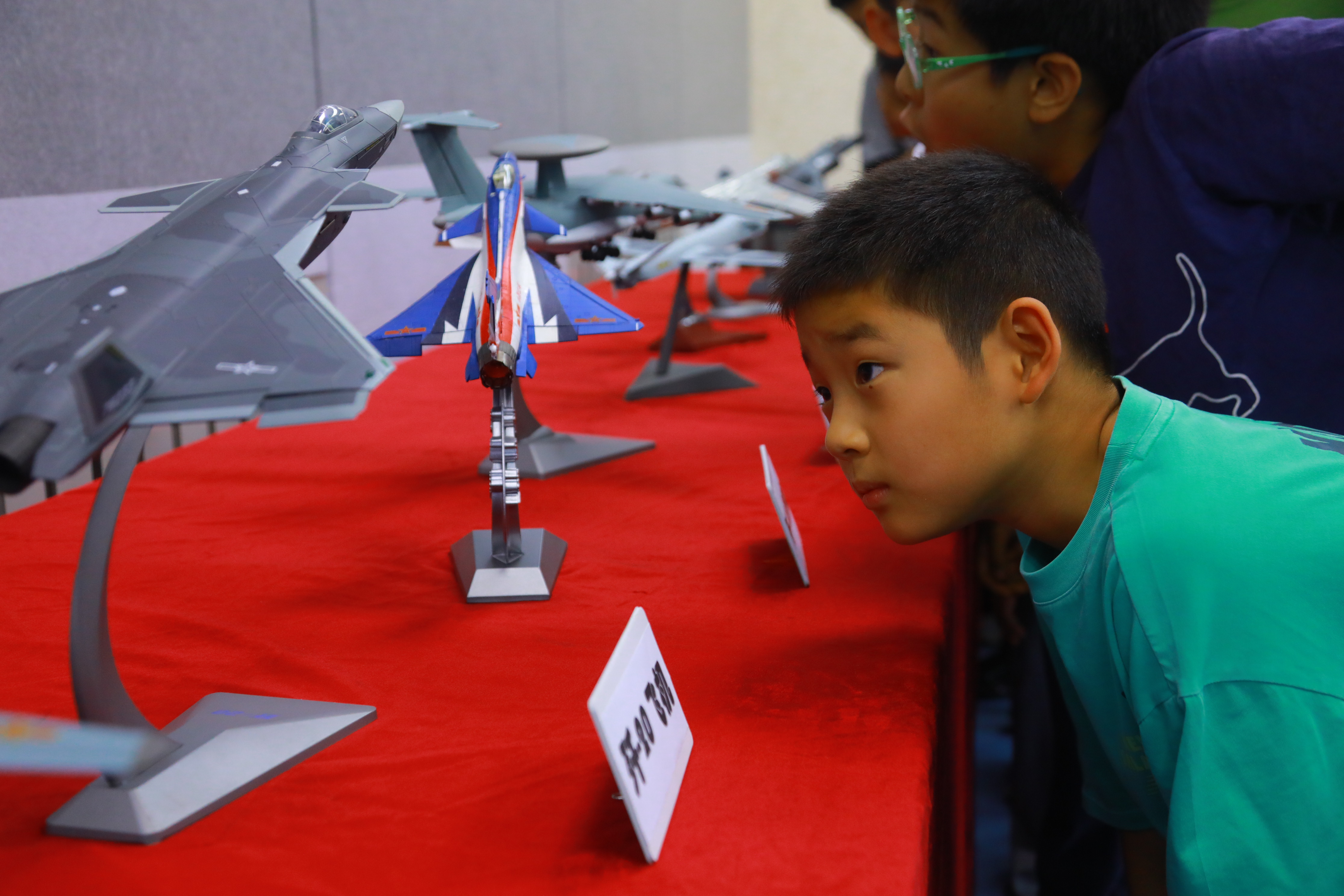 學(xué)生觀看校園空軍飛機(jī)模型展，了解現(xiàn)代空軍科技強(qiáng)國的力量，感受國防科技魅力。府學(xué)胡同小學(xué)供圖