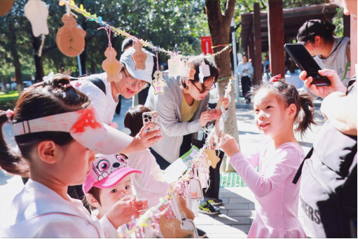 兒童和家長(zhǎng)一起懸掛“環(huán)保心愿倡議”卡片。中國(guó)兒童中心供圖