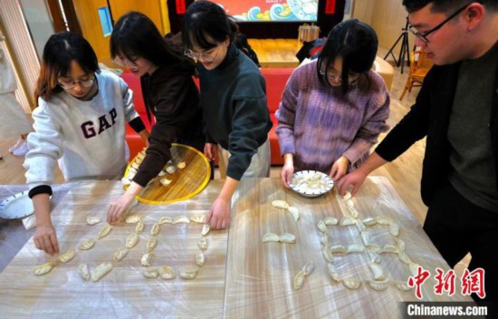 師生們將包好的餃子拼成“加油”字樣。　泱波 攝