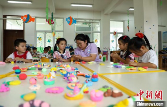在肥西縣山南鎮(zhèn)中心幼兒園，孩子們?cè)诶蠋煹闹笇?dǎo)下做彩色泥塑?！￡惣覙?攝