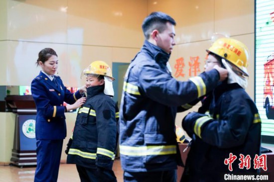 圖為學(xué)生們現(xiàn)場(chǎng)穿戴消防頭盔和戰(zhàn)斗服。中新社記者 趙宇航 攝