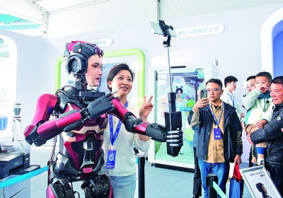 2024年10月24日，第七屆世界聲博會上，人形交互機器人與觀眾合影。新華社發(fā)