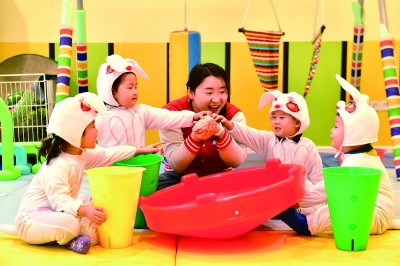 在山東省日照市東港區(qū)一家托幼園，老師陪伴孩子做游戲。新華社發(fā)