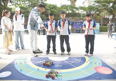 圖為在西安市新城區(qū)華山實驗小學，學生在老師的指導下進行機器人游戲。 新華社記者 張博文攝