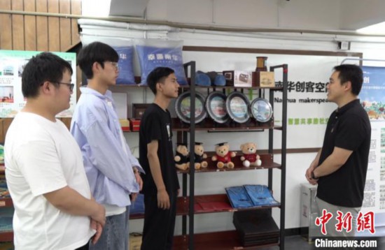 宋宏霖(左三)介紹“大果文創(chuàng)”團(tuán)隊(duì)設(shè)計(jì)的產(chǎn)品。徐志雄 攝