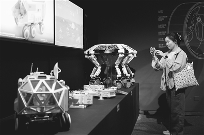 圖為觀眾觀看“宇宙考古：時空探索”展覽上展示的月面多功能平臺及智能火星探測器模型。本報記者 洪星攝