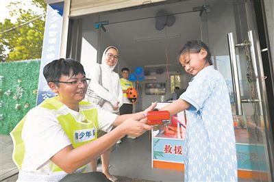 在江蘇省泰州市海陵區(qū)東河小游船碼頭“青少年防溺水救助站”旁，小朋友體驗(yàn)水下救生速浮手環(huán)。