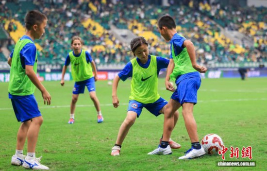 9月26日，參加本次足球夢想啟航營活動的15名新疆足球少年走進北京工人體育場，觀看中超聯(lián)賽比賽。圖為孩子們在比賽中場休息期間登場表演。(中足聯(lián) 供圖)