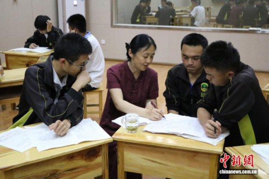 2017年5月3日，王潔(左二)正在輔導梁河一中學生。受訪者 供圖