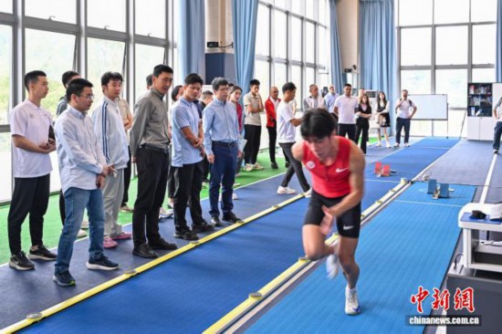 圖為蘇炳添在訓(xùn)練基地內(nèi)了解數(shù)字化跑道分析系統(tǒng)。中新社記者 陳驥旻 攝