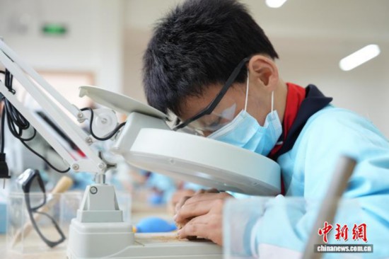 一名小學(xué)生正在清理“化石”上的泥土。劉鴻鶴 攝