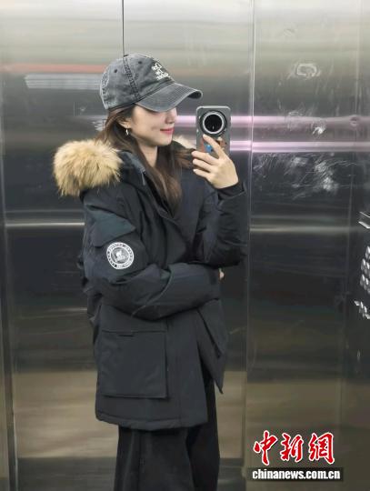 張洛齊身著今年“雙十一”剛開啟時買的羽絨服，這件羽絨服原價890元，折后830元買的。 受訪者供圖