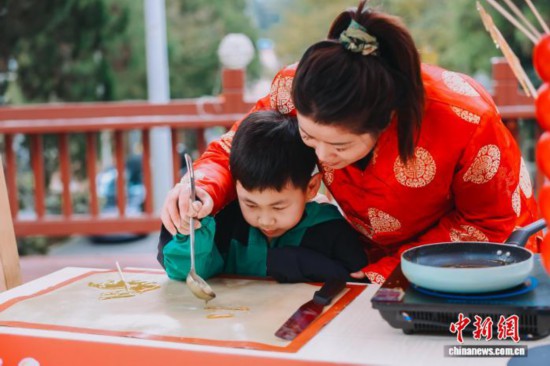 圖為小朋友體驗(yàn)糖畫制作。翁榕飛 攝