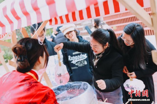 圖為游客體驗(yàn)漆扇制作。翁榕飛 攝