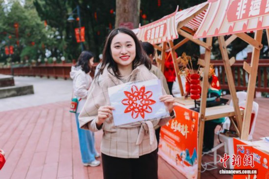 圖為游客展示剪紙作品。翁榕飛 攝